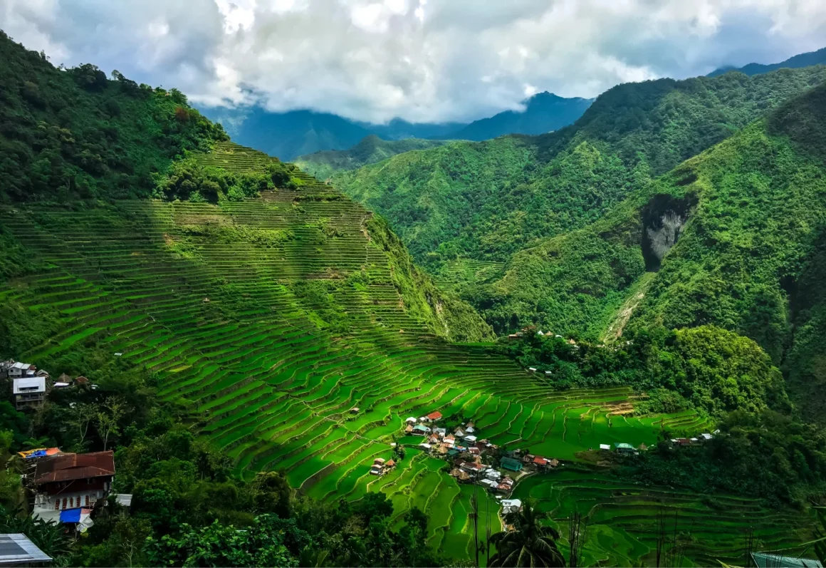 Philippinische Landschaft in grün mit Terassenebenen und einem kleinen Dorf