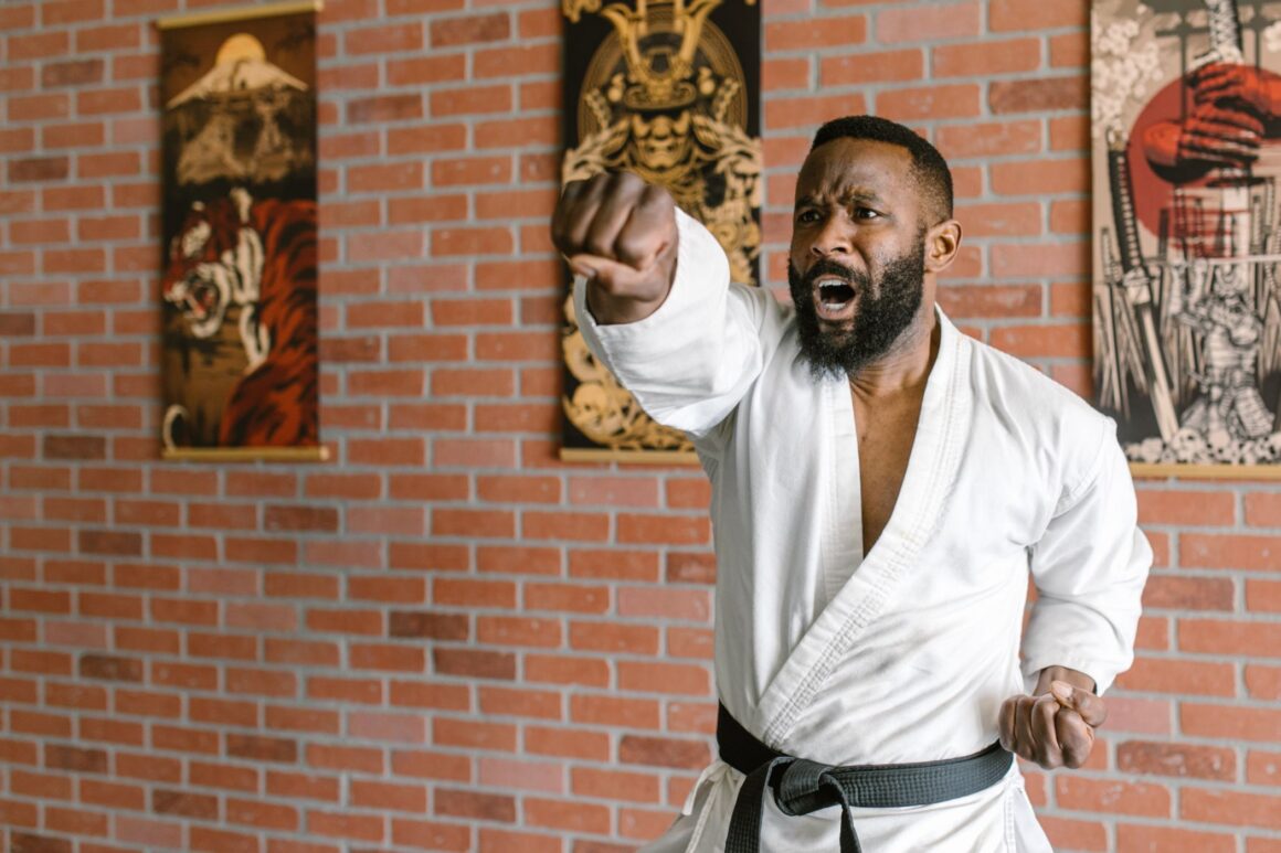 Ein Mann trainiert Karate Schläge im Dojo