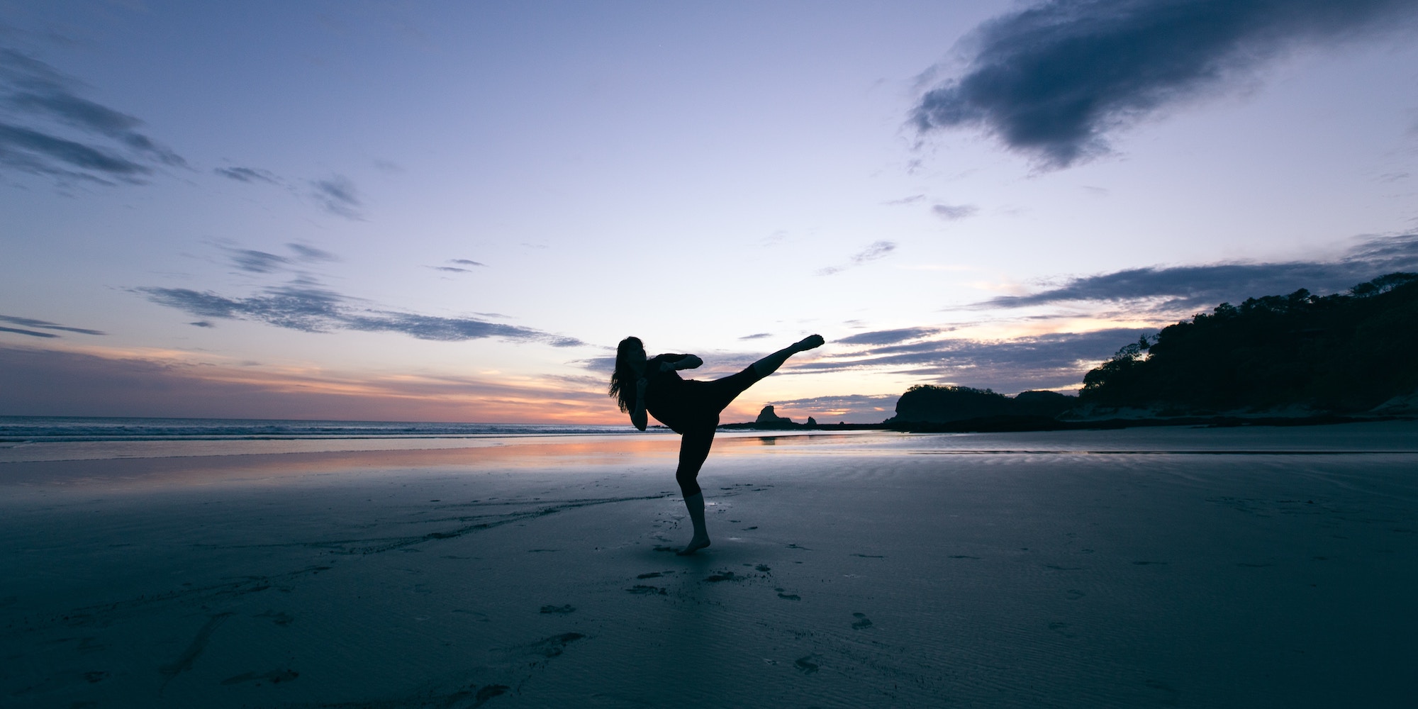 Kampfkunstwelt – Highkick am Strand mit Sonnenuntergang