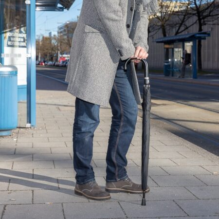 Sicherheitsschirm Gummikappe Herren - ein Herr mit Schirm als Gehilfe mit Kappe zum Schutz der Edelstahlstpitze