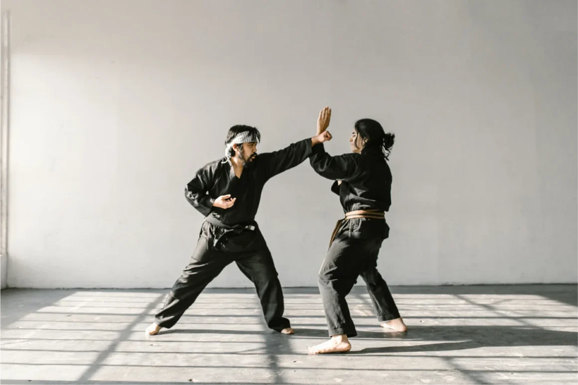 Mann und Frau trainieren Karate in schwarzen Anzügen