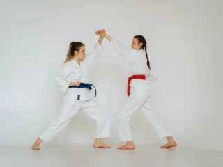 Karate für Frauen – Zwei junge Frauen kämpfen im Karateanzug gegeneinander