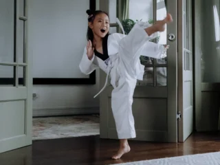 Kind trainiert im Karate Anzug ihre Kampfkunst