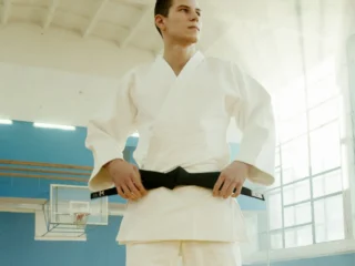 Mann hält den schwarzen Karate Gürtel