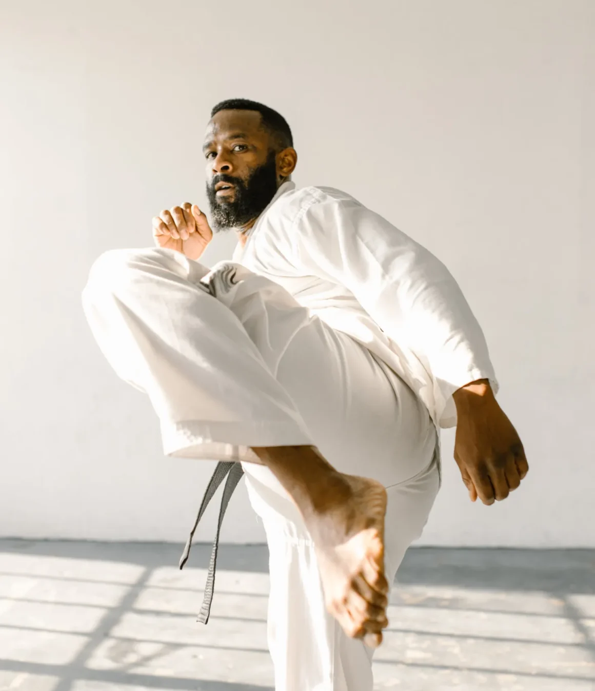 Mann trainiert einen Kick für die Verbesserung seiner Karate Grundtechniken