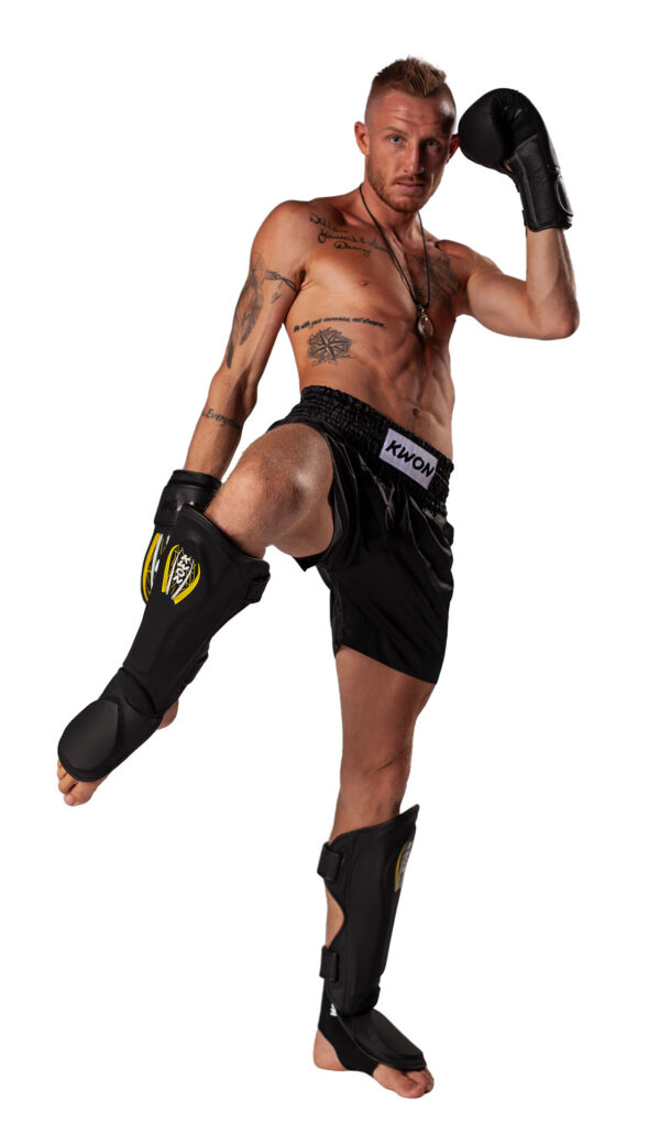 Kwon Schienbeinschützer Kick Thai Spannpolster schwarz - Kampfsportler Frontansicht mit Schienbeinschoner Paar