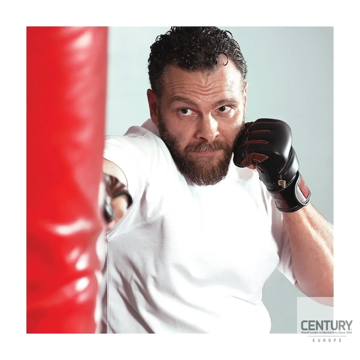 Century Centurion Handschuhe schwarz-braun - Kampfsportler boxt auf Sandsack