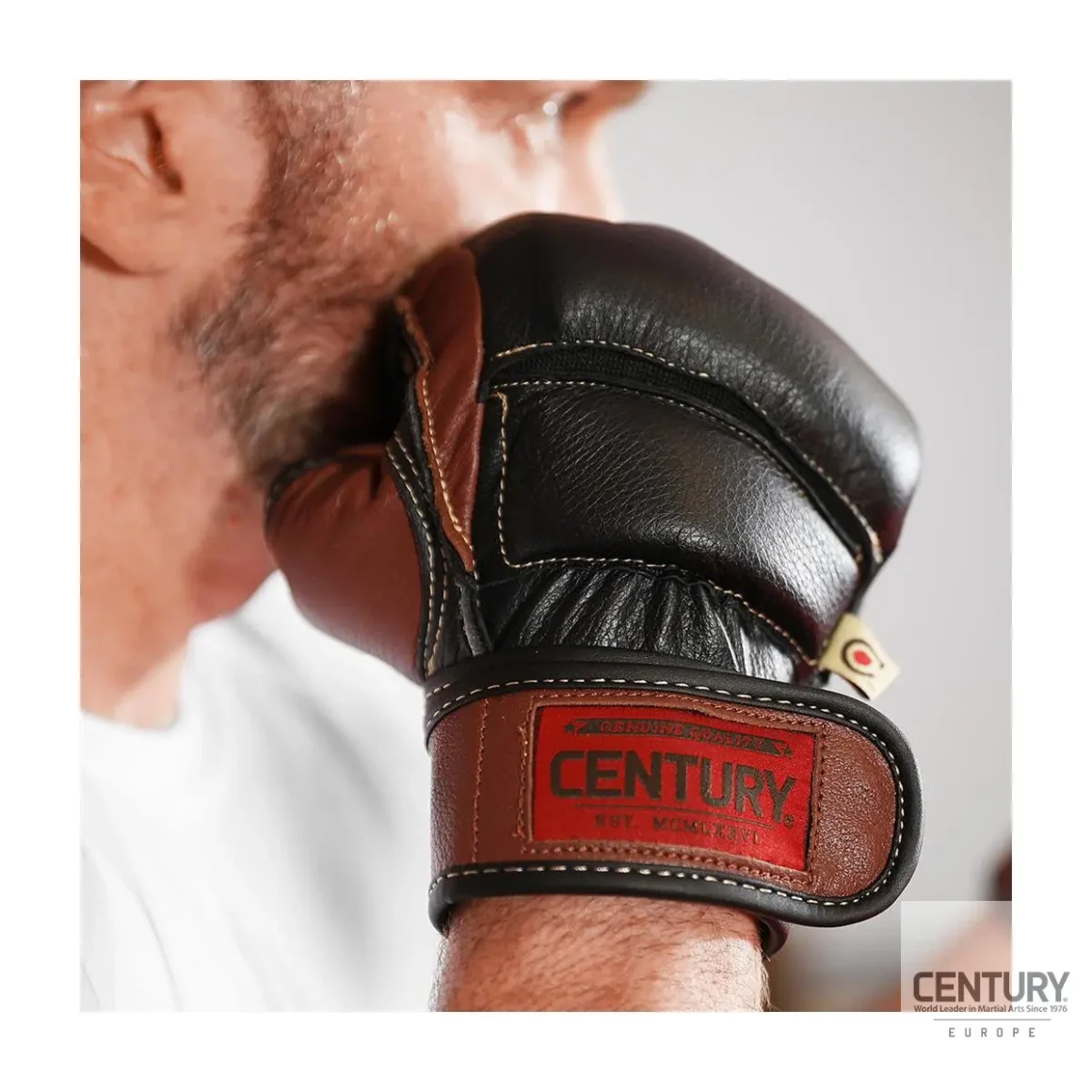 Century Centurion Handschuhe schwarz-braun - Kampfsportler hält Handschuh nah am Gesicht Seitenansicht