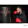Century Brave Boxhandschuhe rot-schwarz - Kampfsportler schlägt auf Boxsack
