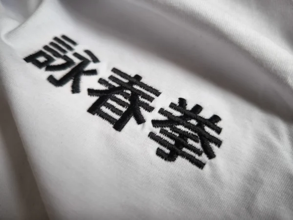 Nahaufnahme der Wing Chun Kuen Stickerei auf dem T-Shirt