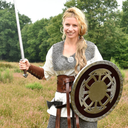 ULFBERTH Wikinger Rundschild, Schaukampftauglich (Holz, Stahl, Leder) 54,5 cm Durchmesser - eine Wikingerkriegerin steht mit Schwert, Axt und Schild auf einer Wiese