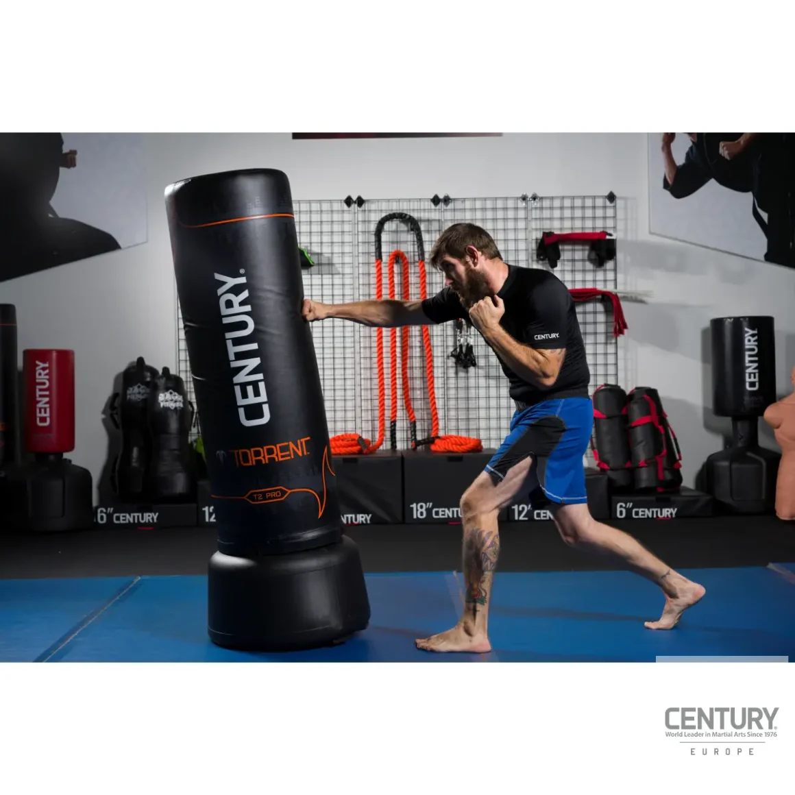Century Torrent T2 Pro Standboxsack schwarz - Sportler schlägt mit der rechten Faust an die mittlere Hälfte des Boxsacks