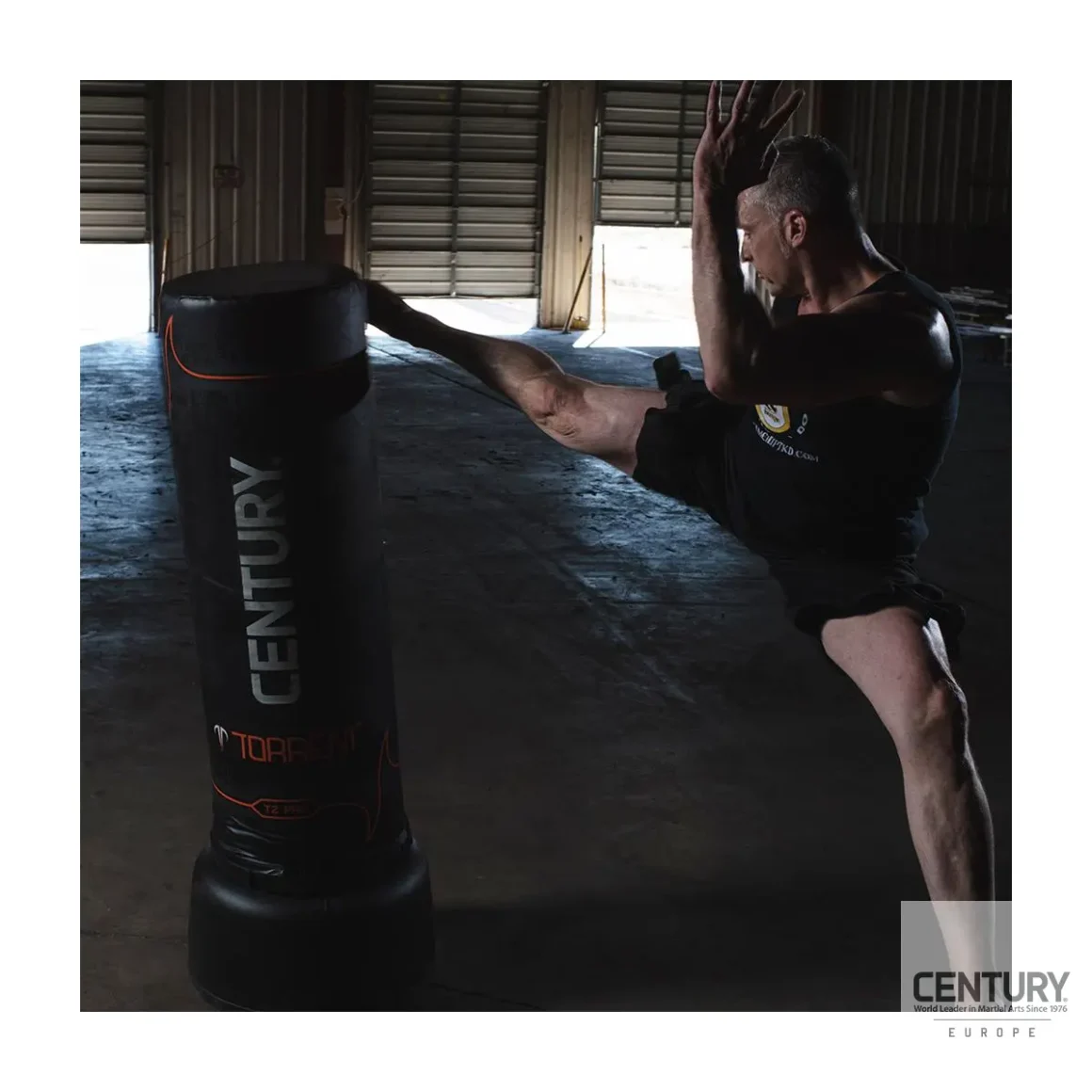 Century Torrent T2 Pro Standboxsack schwarz - Sportler kickt mit dem rechten Fuß an die obere Kante des Boxsacks