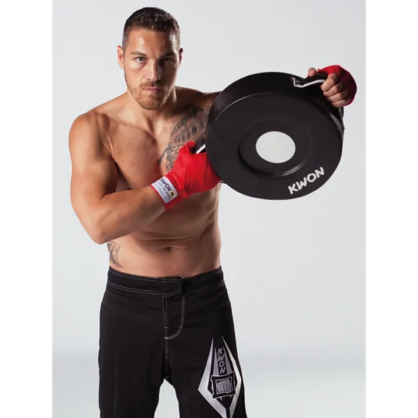 Kwon Kombi Pad Leder schwarz - Kampfsportler hält es an beiden Griffen auf seiner linken Seite hoch