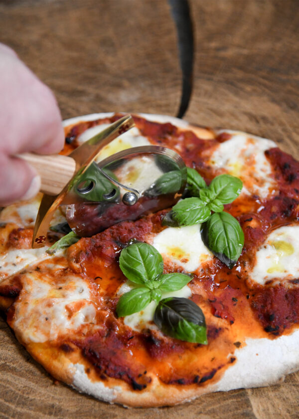 Battle Merchant Pizzaschneider Pizzaroller Templer Schwert Edelstahl, Eschenholz, Messing, Emaille - in einer Hand, die gerade die Pizza Mozarella schneidet, Ansicht von oben