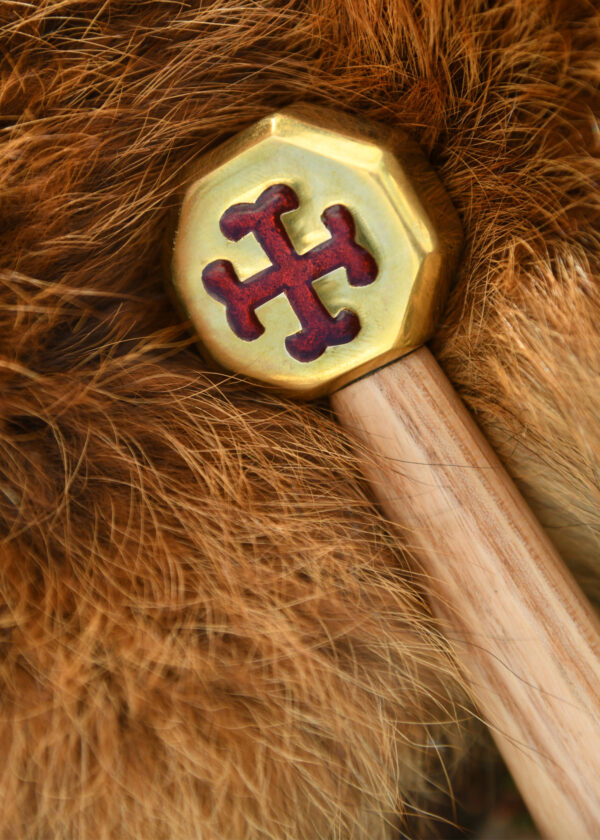 Battle Merchant Pizzaschneider Pizzaroller Templer Schwert Edelstahl, Eschenholz, Messing, Emaille - liegt auf einem Stück Tierfell, Nahaufnahme Griff