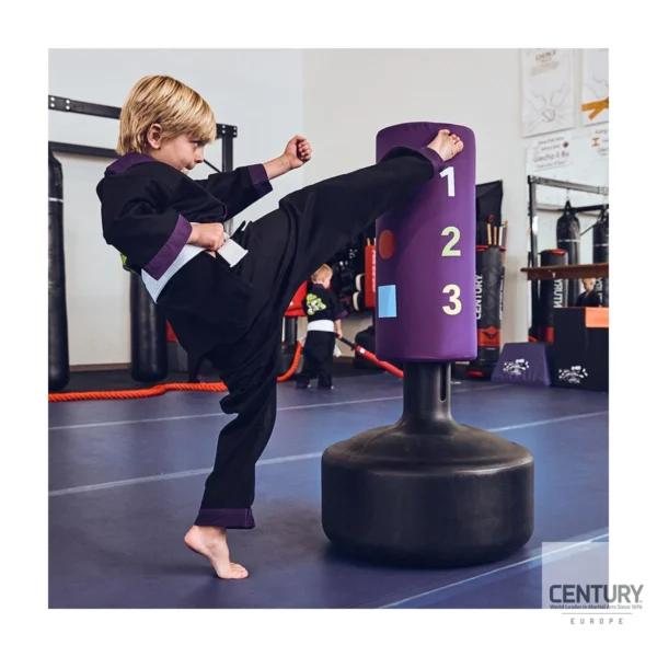 Lil Dragon Wavemaster - Junger Kampfsportler tritt mit dem rechten Bein am oberen Punkt auf Standboxsack ein